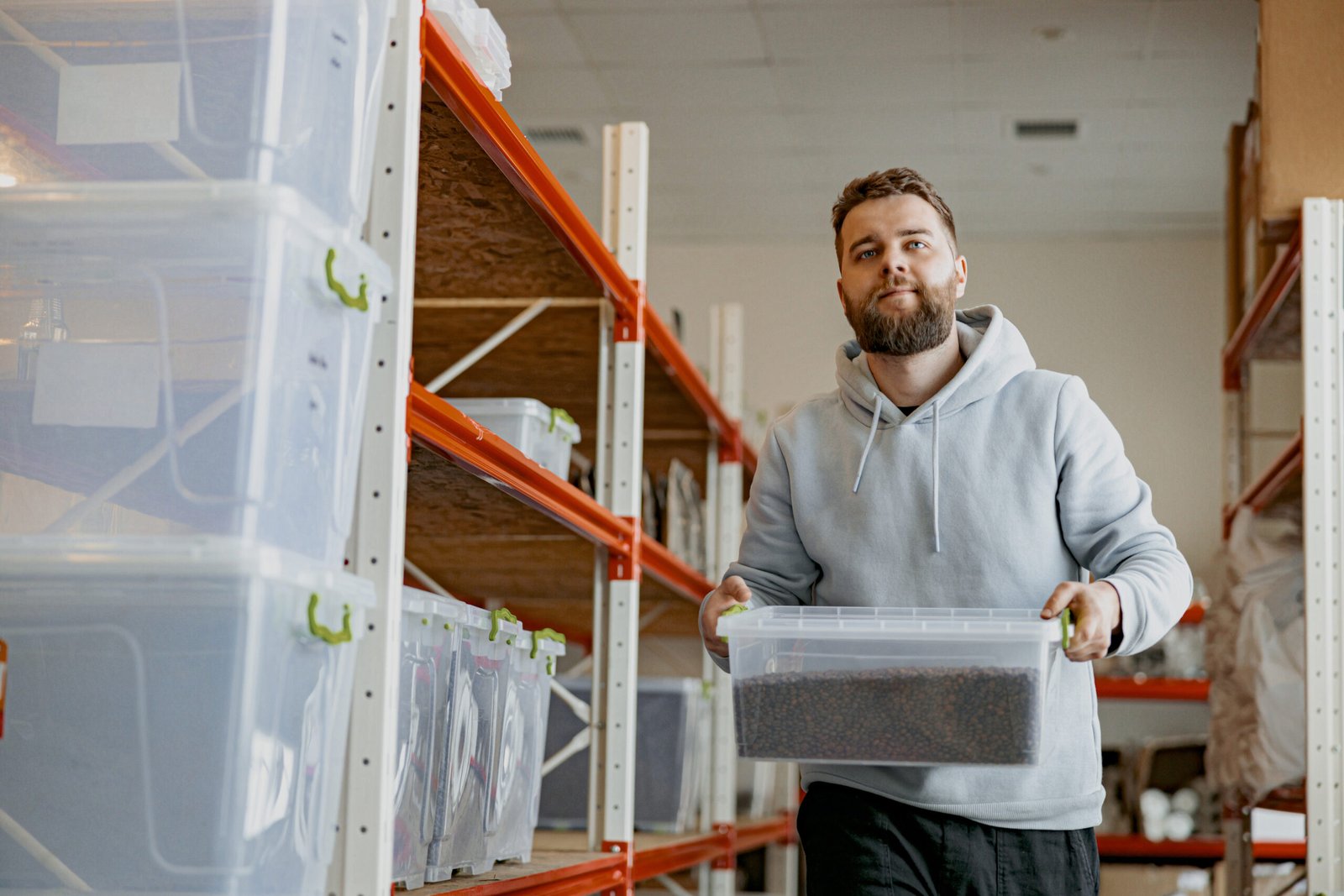 Entrepreneur stacks boxes of roasted coffee beans on a shelf in a warehouse. High quality photo
